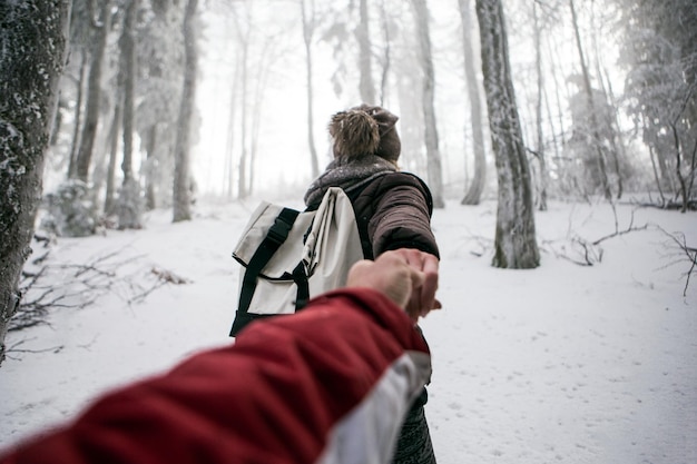 Foto casal na floresta coberta de neve