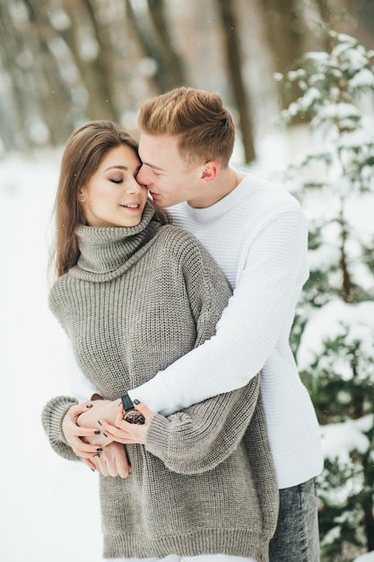 Casal na floresta de inverno