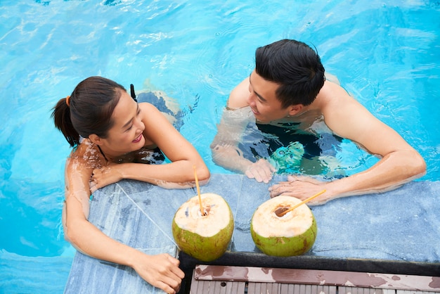 Casal nadar com cocktails