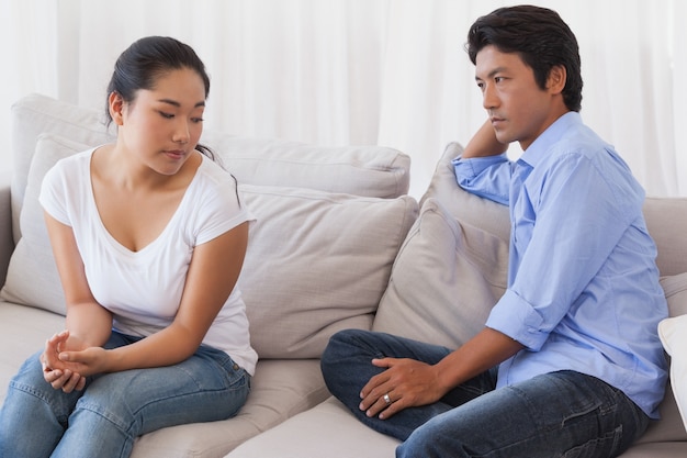 Casal não falando depois de uma disputa no sofá