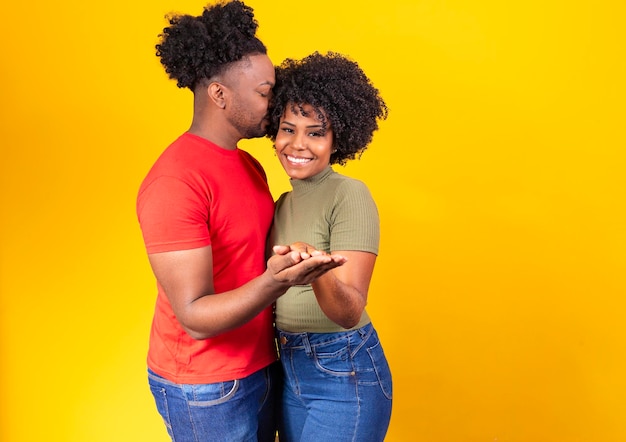 Casal negro apaixonado dançando em fundo amarelo com espaço livre para texto