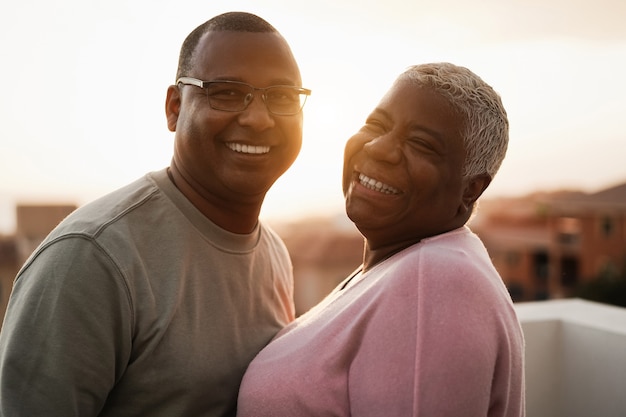 Casal negro feliz tendo um momento de ternura ao ar livre ao pôr do sol de verão