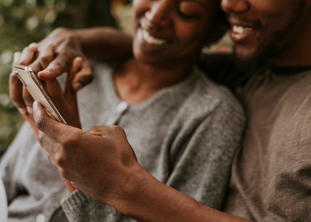 Casal negro feliz usando um smartphone