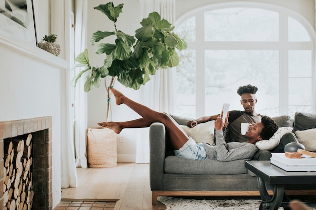 Foto casal negro romântico fofo lendo um livro no sofá