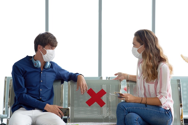 Foto casal no aeroporto usando máscaras