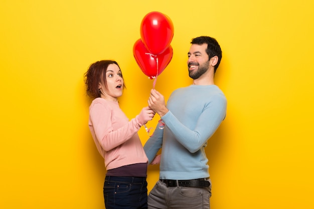 Casal no dia dos namorados com balões com forma de coração