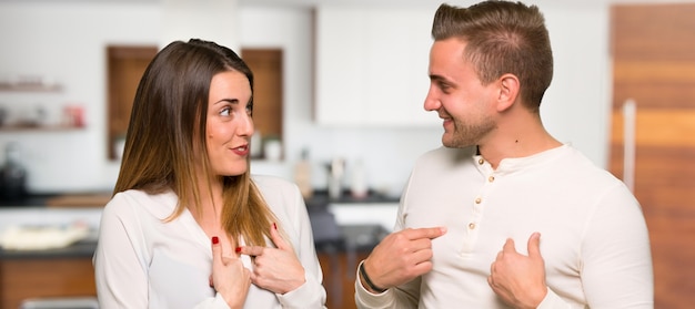 Foto casal no dia dos namorados com expressão facial de surpresa em uma casa