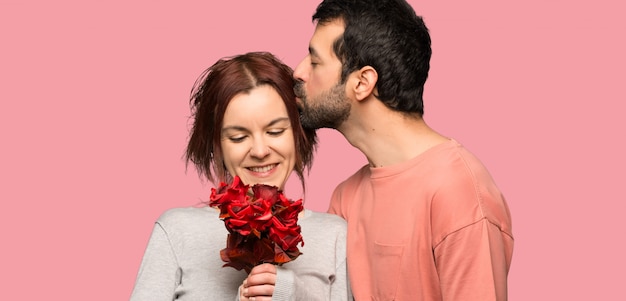 Casal no dia dos namorados com flores sobre fundo rosa isolado