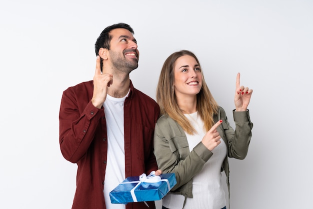 Casal no dia dos namorados segurando um presente isolado parede apontando para cima com o índice