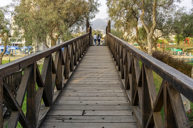 Foto casal no final de uma ponte de madeira