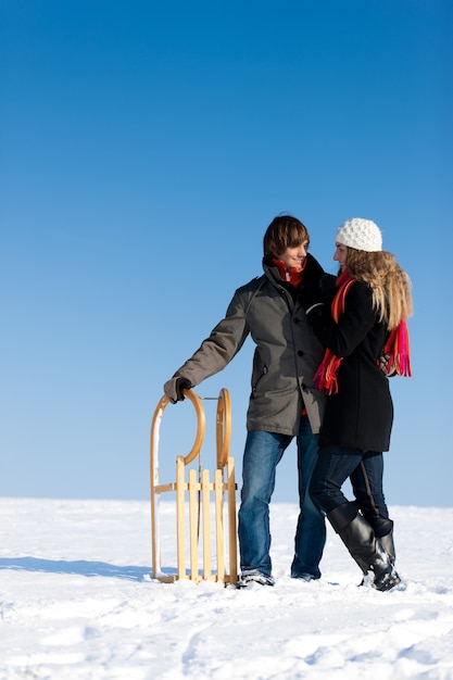 Casal no inverno com trenó