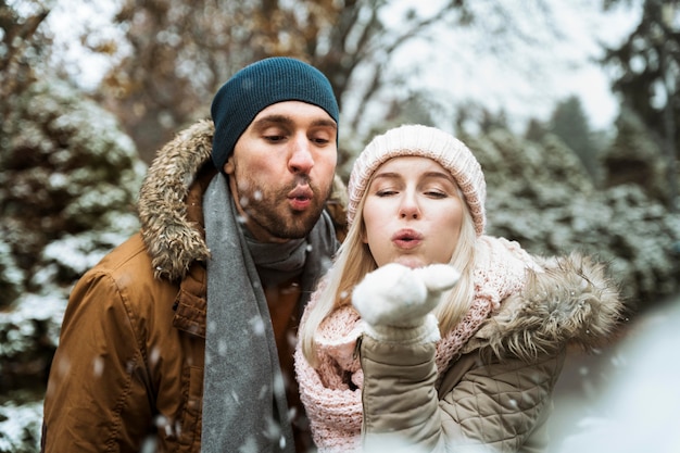 Casal no inverno soprando na neve