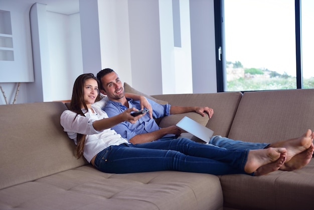 Casal no sofá com controle remoto da TV