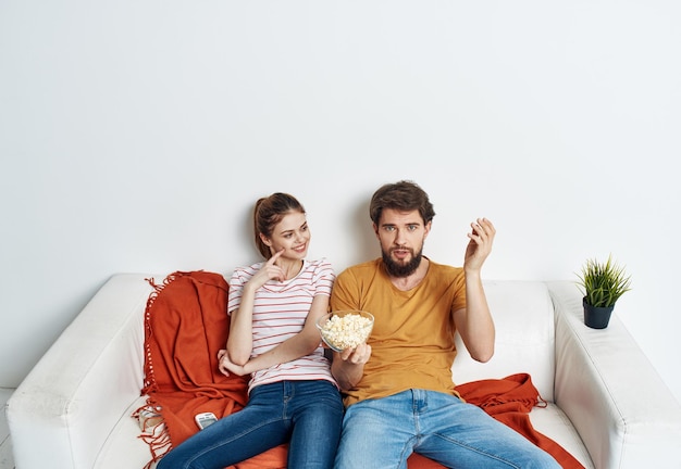 casal no sofá popcorn assistindo televisão dentro de casa homem mulher foto de alta qualidade