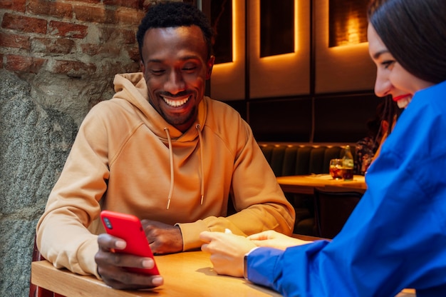 Casal olhando para o celular em uma cafeteria