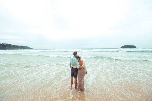 Casal olhando para o mar em roupas de casamento. Phuket. Tailândia. vista traseira