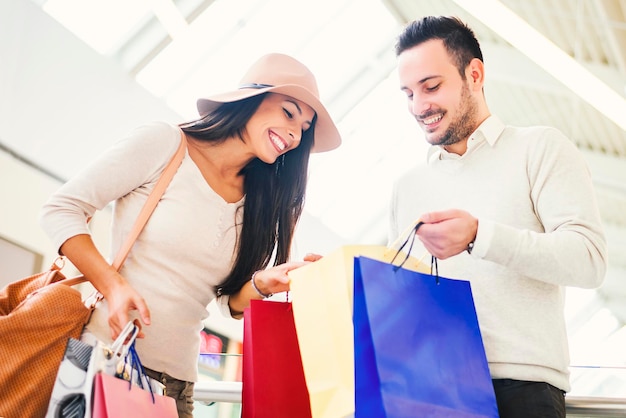 Foto casal olhando suas sacolas de compras