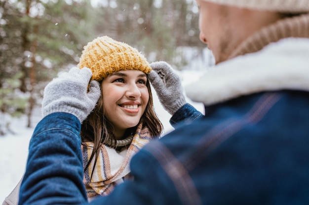 casal olhando um para o outro na floresta de inverno