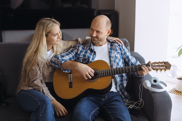 Casal passar o tempo em casa tocando guitarra