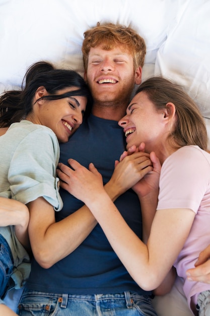 Foto casal poliamoroso abraçando em casa