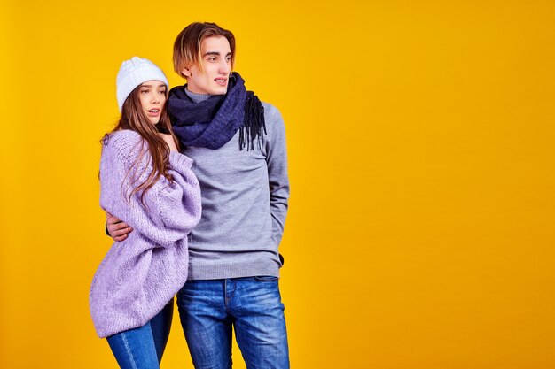 Casal posando em jeans tipo estilo de moda comercial na parede amarela