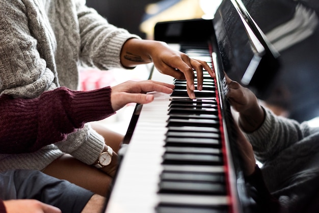 Casal praticando em um piano juntos