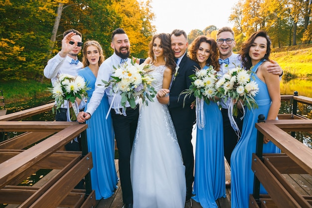 Casal recém-casado com padrinhos e damas de honra posando para cerimônia de casamento