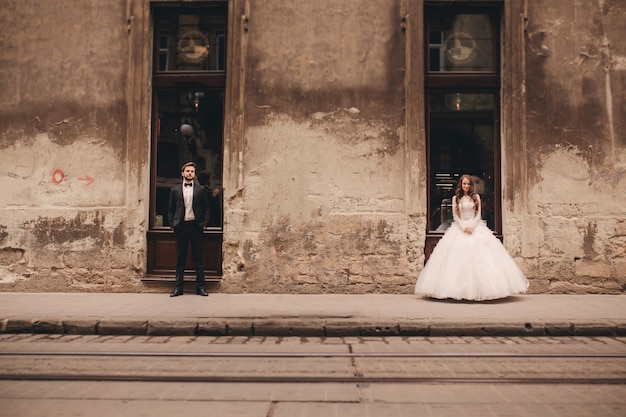 Foto casal recém-casado feliz em um passeio na antiga rua de uma cidade europeia