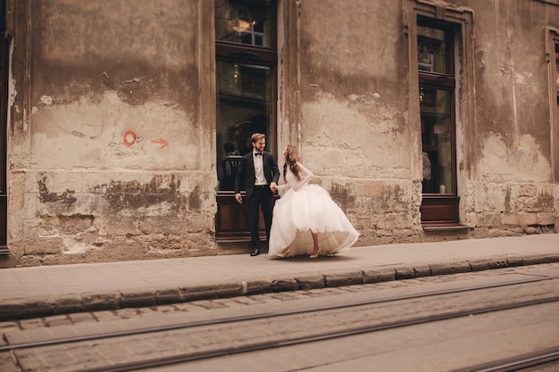 Casal recém-casado feliz em um passeio na antiga rua de uma cidade europeia
