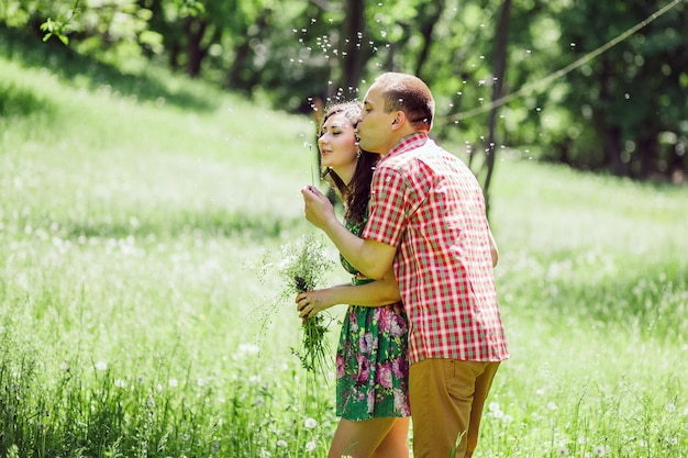 Casal relaxa no jardim verde. Lindo casal anda no prado verde.