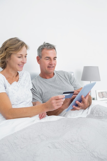 Casal relaxado usando seu tablet PC para comprar on-line