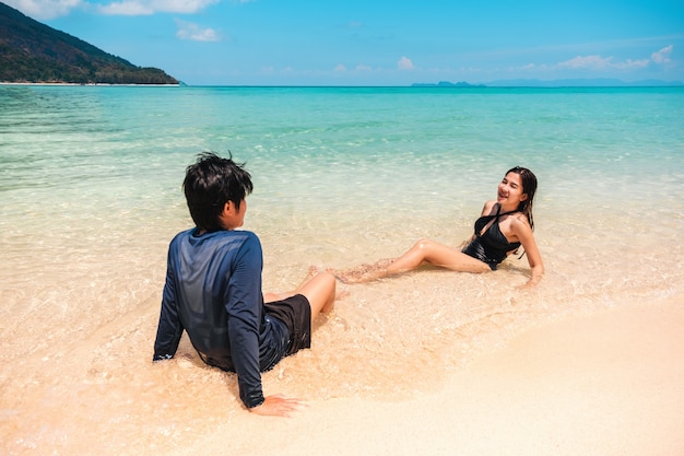 Casal relaxando na praia de férias de verão