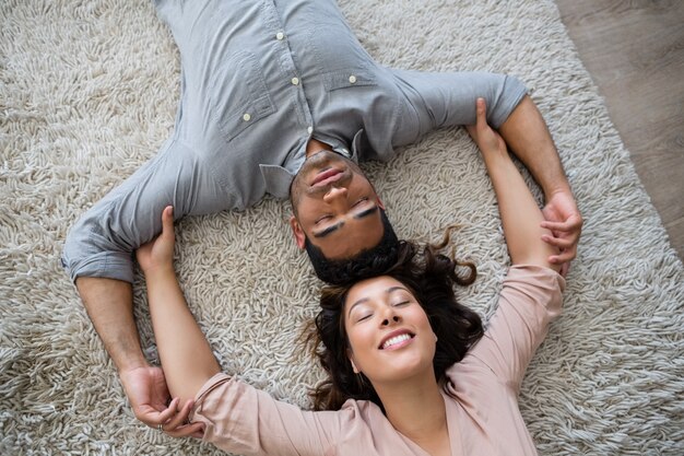 Casal relaxando no tapete na sala de estar