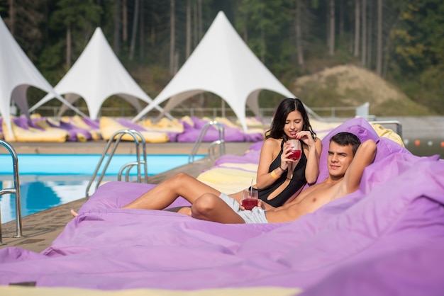 casal relaxando perto da piscina