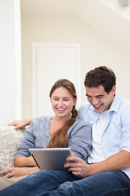 Casal rindo enquanto segura um laptop