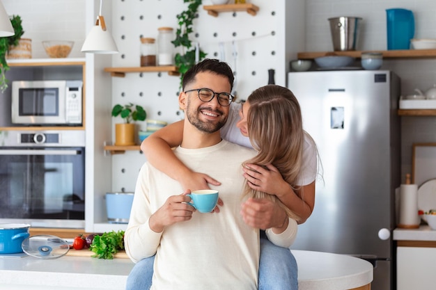 Casal romântico apaixonado passando tempo juntos na cozinha Jovem casal bonito tomando café na cozinha e aproveitando o tempo da manhã juntos