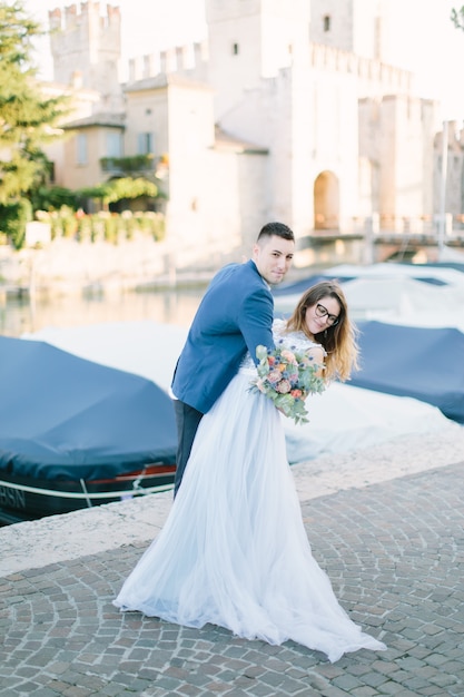 Casal romântico apaixonado se divertindo abraçando e rindo em Sirmione, Itália. Amor na Itália