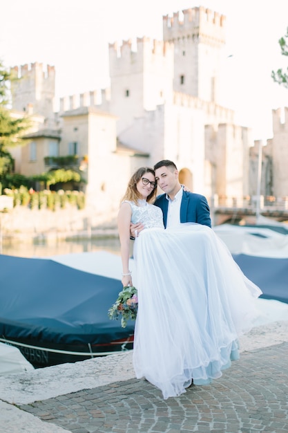 Casal romântico apaixonado se divertindo abraçando e rindo em Sirmione, Itália. Amor na Itália