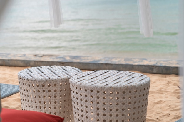 Casal romântico closeup cadeira de tecido branco na praia de areia perto do mar, lugar para relaxar com vista para o mar
