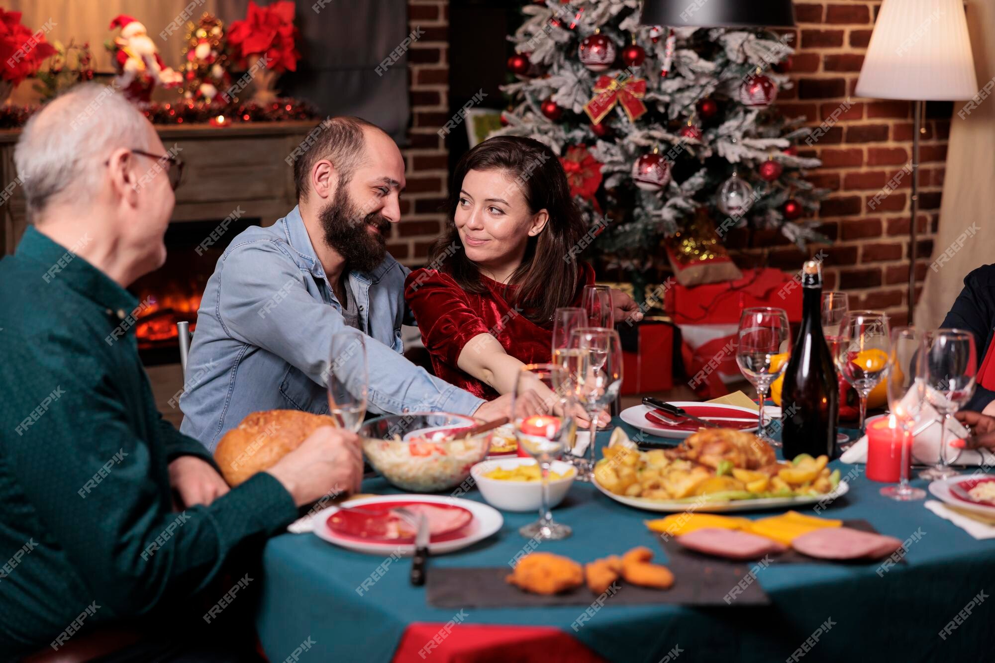 Casal romântico comemorando o natal com a família, feliz namorado e namorada conversando na mesa de jantar festiva. celebração de natal, esposa e marido comendo refeição tradicional com os pais | Foto Casal romântico comemorando o natal com a família, feliz namorado e namorada conversando na mesa de jantar festiva. celebração de natal, esposa e marido comendo refeição tradicional com os pais | Foto
