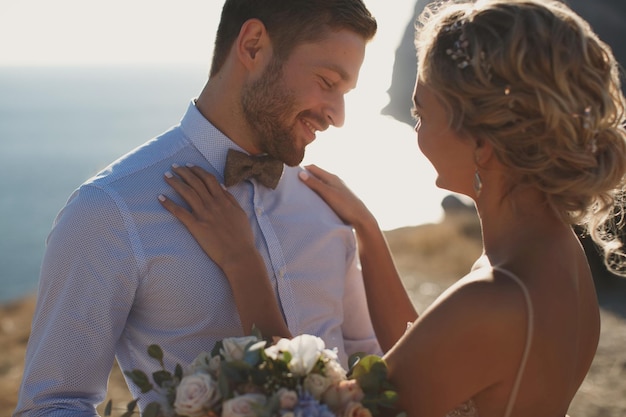 Casal romântico de conto de fadas de recém-casados abraços e beijos ao pôr do sol