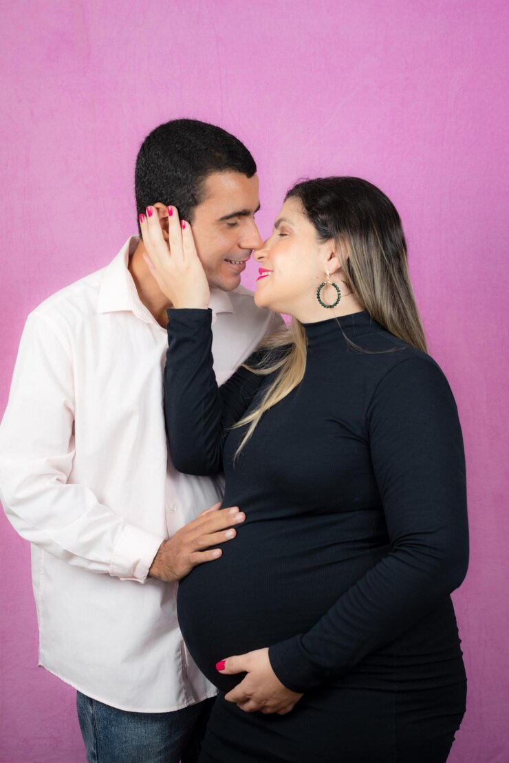Foto casal romântico de marido bonito e bela esposa grávida posando em estúdio estúdio retrato