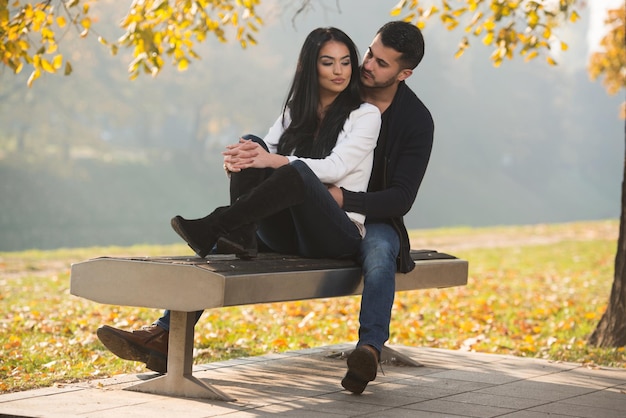 Casal romântico em um banco no parque outono