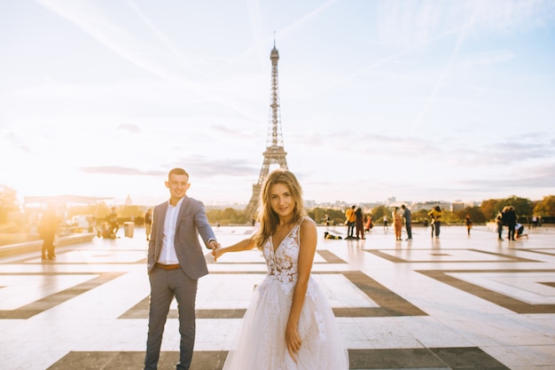 Casal romântico feliz abraçando perto da torre Eiffel em Paris