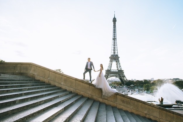 Casal romântico feliz abraçando perto da torre eiffel em paris