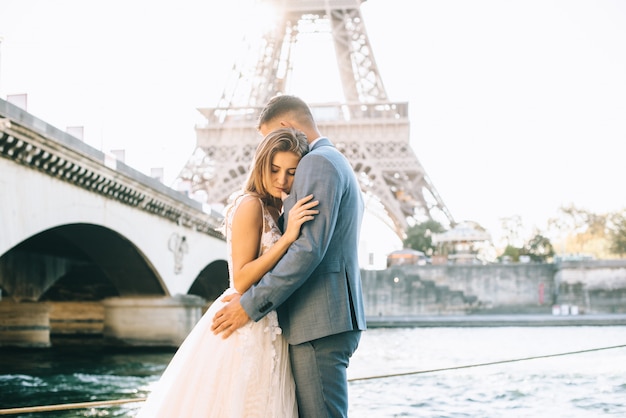 Casal romântico feliz abraçando perto da torre eiffel em paris