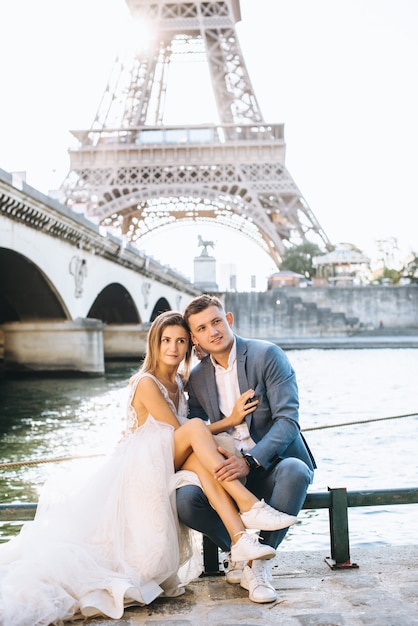 Casal romântico feliz abraçando perto da torre Eiffel em Paris