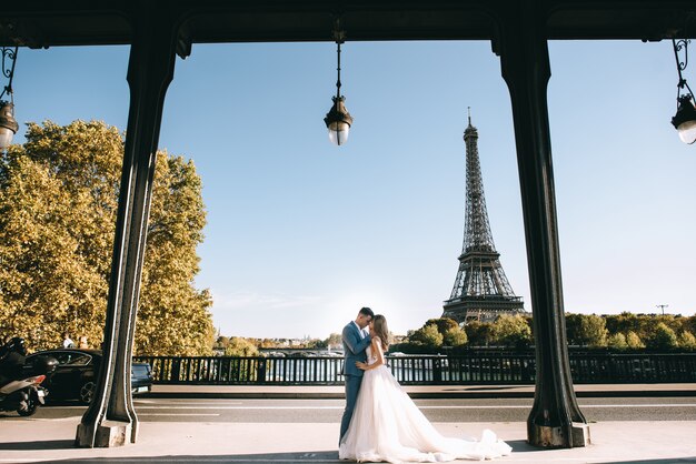 Casal romântico feliz abraçando perto da torre Eiffel em Paris