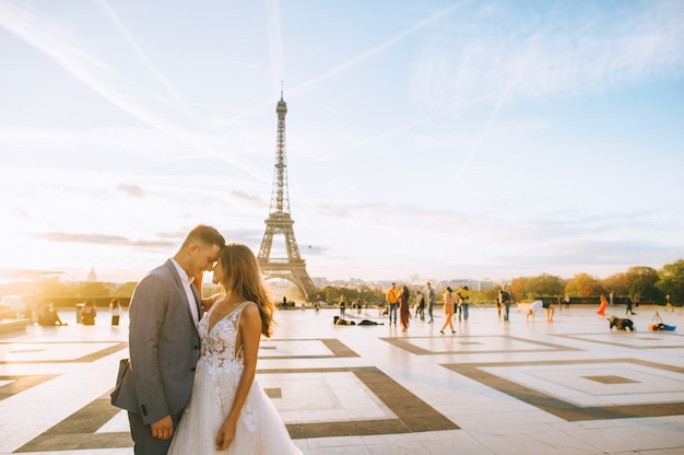 Casal romântico feliz abraçando perto da torre Eiffel em Paris