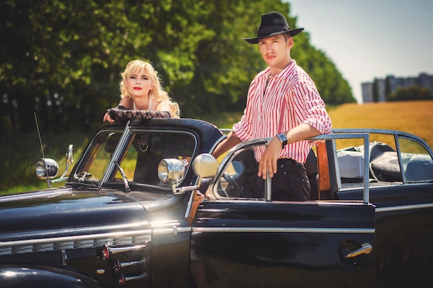 Foto casal romântico juntos no carro preto retrô